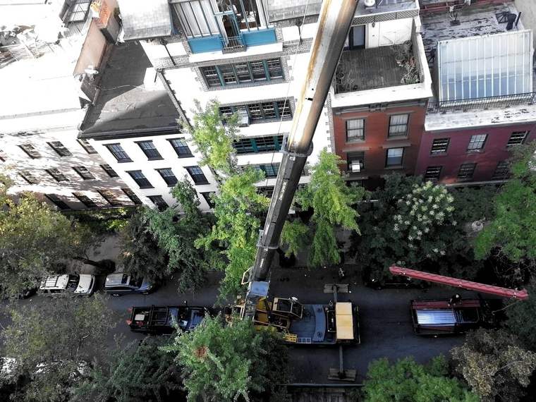 Crane hoisting steel to a townhouse roof