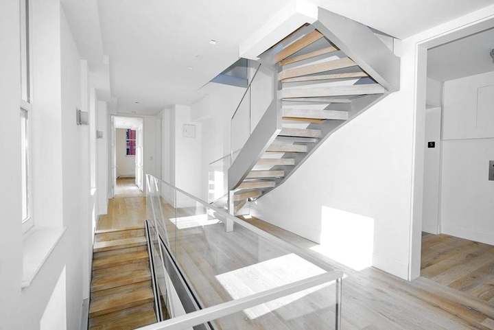 Floating stair with wood treads and a glass guard